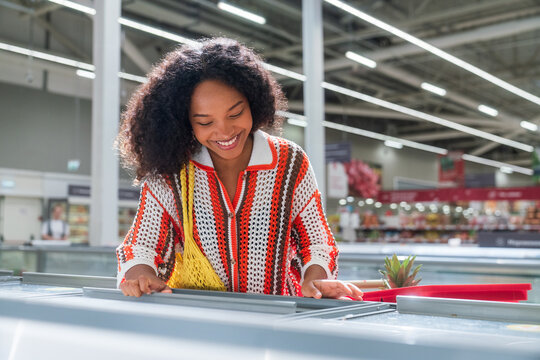 Smiling Woman Shopping in Freezer Section