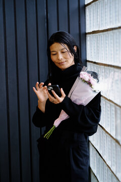 Woman With Flowers Texting in a Contemporary Urban Setting