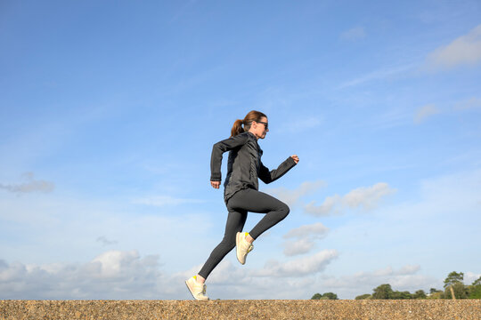 Woman Jogging Along a Concrete Path
