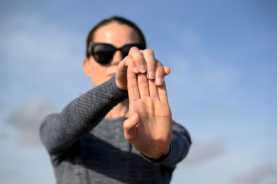 Close-up of a woman's hand held up in front doing a Finger Stretch