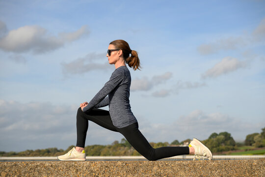 Woman Practicing Yoga on a Stone Wall, Lunge.