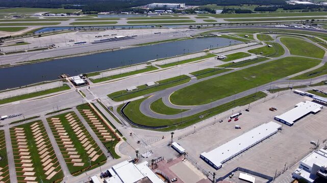 An aerial 4K video pans right across Daytona infield roads and paved pads.