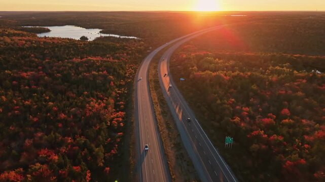 Golden autumn light shines over a curving nova scotia highway and solar panels in canada