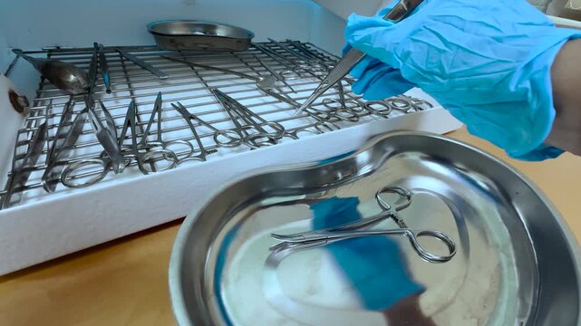 Assistant preparing sterile surgical instruments before operation in surgery department
