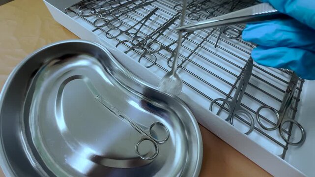 Surgical assistant laying out sterile instruments before operation in clinic