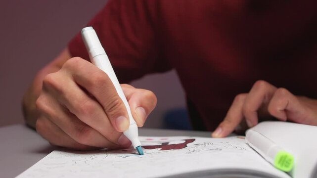 Hands sketching in open sketchbook with scattered colored markers on tabletop during creative drawing session, closeup view of marker tips and paper surface, warm indoor light, casual workspace mood,,