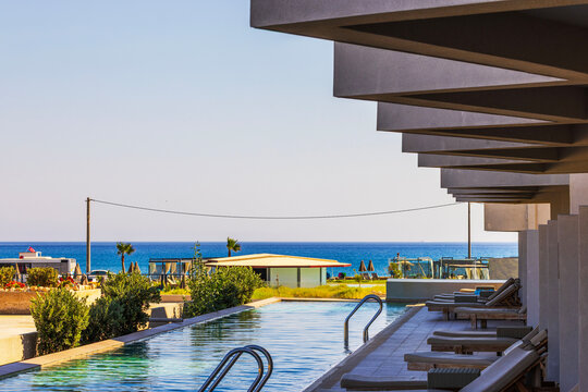 Beautiful view of seaside resort pool overlooking Mediterranean Sea from shaded terrace. Crete. Greece.