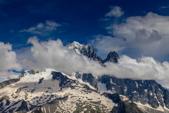 Impressive view of Les Drus, a dramatic pair of granite peaks in the Mont Blanc massif of the French Alps near Chamonix. The iconic mountain formation rises above deep alpine valleys