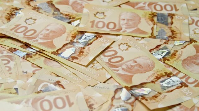 Golden light glimmers across a scattered sea of Australian hundred-dollar banknotes in a richly textured still life