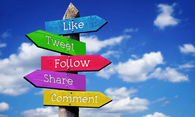 Like, tweet, follow, share, comment - wooden signpost with five arrows, sky with clouds © PX Media