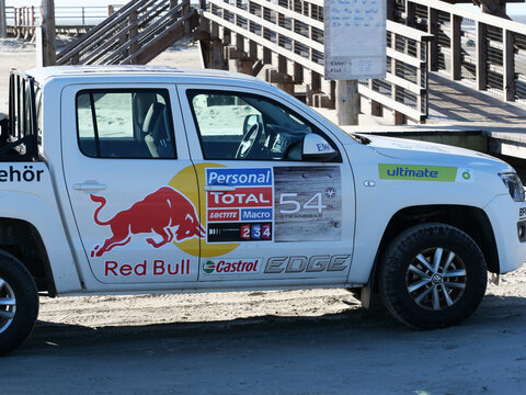 Germany, St. Peter Ording, October 17. 2026, white Volkswagen Amarok pickup truck with various racing and sponsor decals including Red Bull, Castrol EDGE, Total, and Volkswagen Zubeh&ouml;r