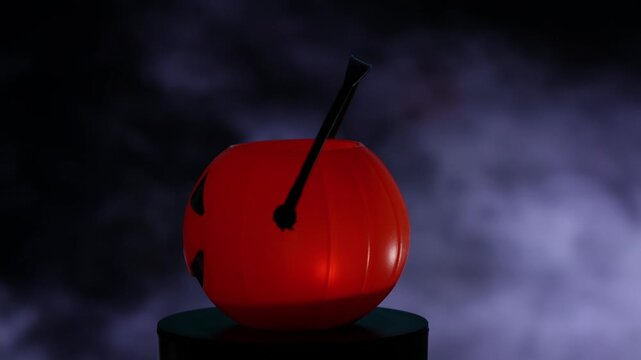 Close-up of an illuminated Halloween pumpkin basket spinning amidst fog, atmosfericbackground