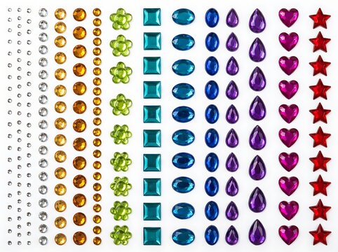 A flat lay sheet of assorted colorful adhesive gemstone stickers featuring various geometric shapes and sizes isolated