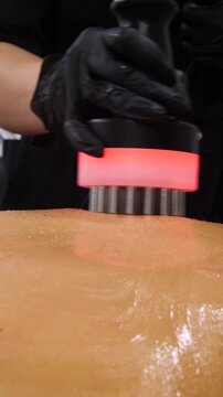 Professional body shaping therapy with vibromassage thermo vacuum and bioelectrical stimulation in beauty salon - vertical video