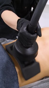 Professional body shaping therapy with vibromassage thermo vacuum and bioelectrical stimulation in beauty salon - vertical video
