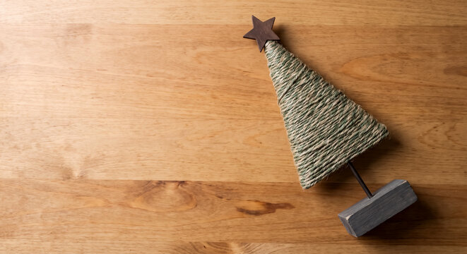 Handmade yarn christmas tree star topper on wooden base flat lay