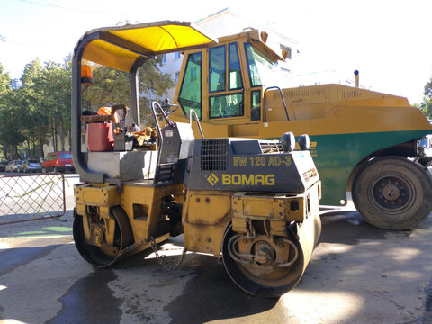 Bendery, Moldova - September 7, 2021: roller - road machine for compacting fresh asphalt. A road work machine is standing on the side of the road. compaction of fresh asphalt. Men at work