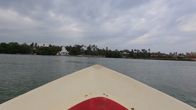 Boat sailing towards a white Buddha statue in Sri Lanka