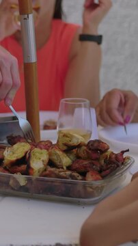 Friends sharing barbecue food at outdoor table celebrating summer togetherness