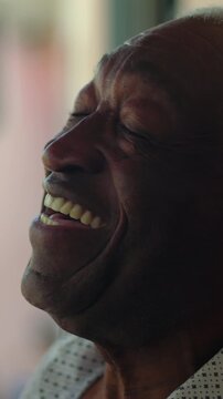 Joyous African American senior man laughing cheerfully outdoors, conveying vitality