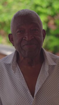 Portrait of senior man of African descent standing outdoors with calm, gentle smile