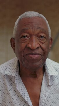 Elderly African American man close up portrait outdoors, calm neutral expression