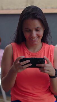 Excited woman laughing while looking at smartphone outdoors, cheerful good news