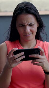 Frustrated woman frowning at smartphone screen outdoors, confused by message