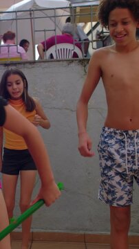 Lively kids dodging broomstick in outdoor patio game, carefree playful moment