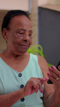 Smiling African American woman holding green screen smartphone outdoors, app mockup