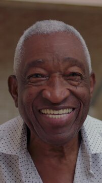 Smiling elderly African American man close up portrait outdoors, joyful senior