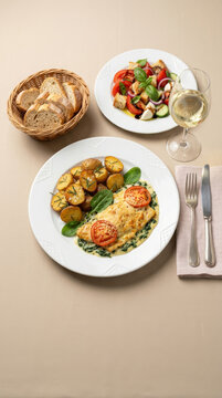 Fish gratin with b&eacute;chamel sauce and spinach, served with rosemary-roasted potatoes, a fresh salad, and bread, accompanied by white wine - peixe &agrave; fiorentina 