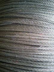 Close-up detail of heavy duty steel wire rope roll texture background. Metallic cable sling wrapped tightly for industrial and construction background concept. © SARTONO  