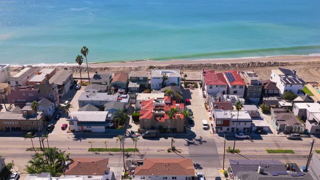 Long Beach, California, USA - October 15, 2026: Flight right to left over Ocean Boulevard and Peninsula homes, a fresh sand berm on the beach shielding them from the surf after Tropical Storm Rachel.