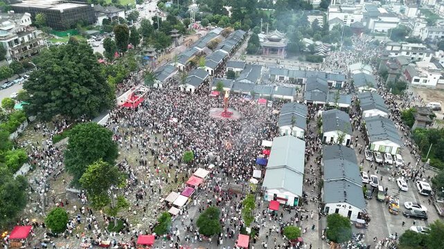 Aerial shot of people gathering for the Torch Festival ceremony in a traditional town, Southwest China, D-Log lossless file format