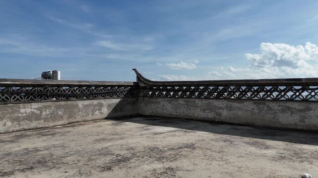 Aerial low flight over an ancient city wall with upturned eaves under blue sky, Southwest China, D-Log lossless file format