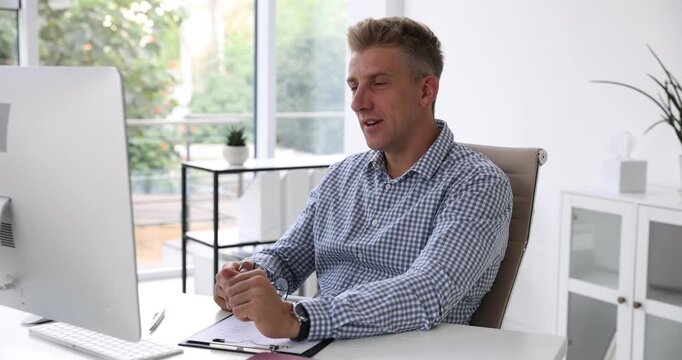 Human resources manager conducting online job interview via video chat on computer at table indoors