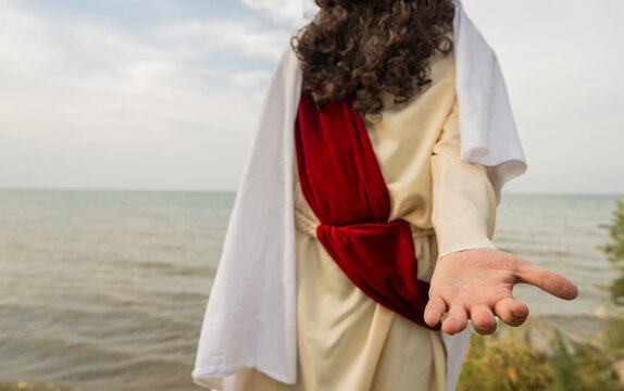 Jesus Christ extends His hand in a gesture of help and compassion.
