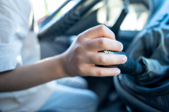 A little boy behind the wheel of his dad's car.