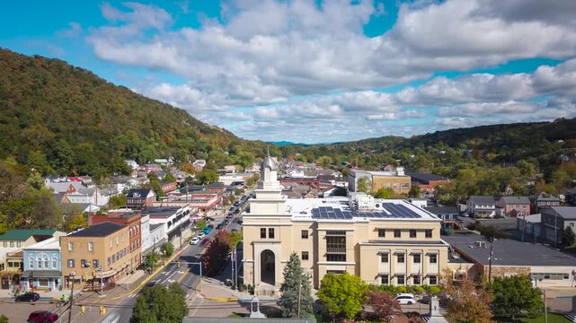 Aerial hyperlapse over Bath in Berkeley Springs, West Virginia, as cars and clouds rush through a bright autumn day.