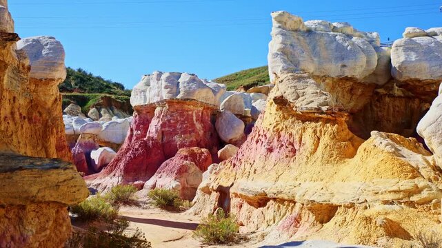 Towering white-capped hoodoo rock formations rise against a vibrant blue sky at Paint Mines Interpretive Park in Calhan, Colorado