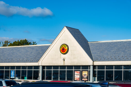 Ramsey, NJ - US - Oct 12, 2026 : A closer view of the ShopRite supermarket highlights its triangular entrance gable, round red and yellow store logo, broad windows, gray shingle roof, and parked cars.