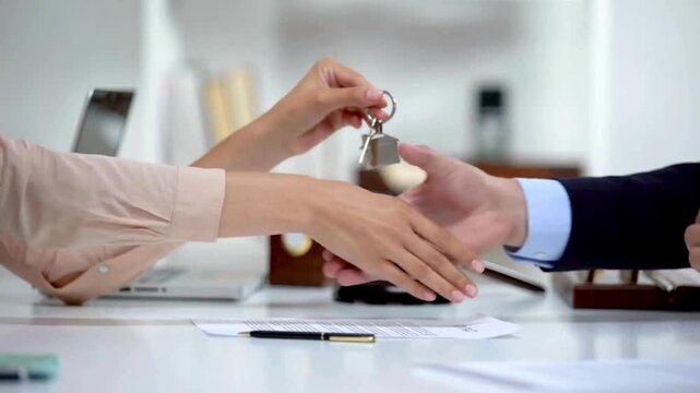 Signing Real Estate Documents While Holding a House Key. Close-up of a person signing paperwork while holding a house key, representing property purchase agreements, real estate transactions. 