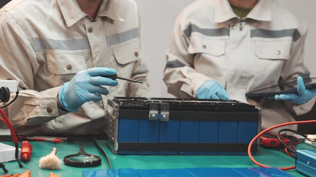 Technician handling lithium iron phosphate battery in workshop Great for clean energy campaigns, EV content, or sustainable tech education