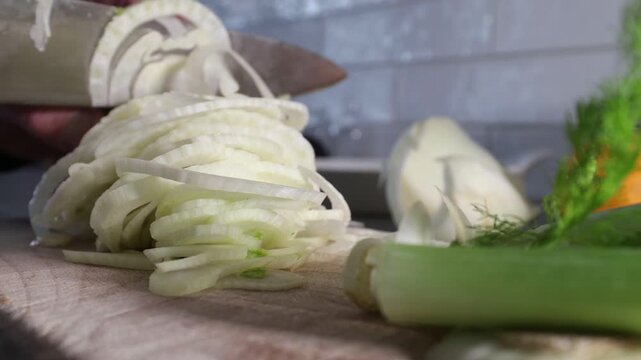 Stockholm, Sweden A cook finely slices a fennel bulb on a wooden board to make a salad. 