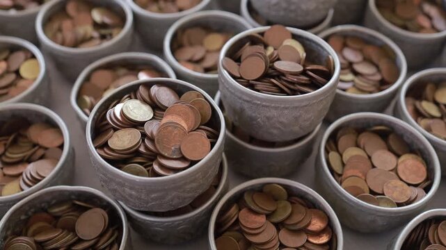 Thai copper coins filled in small silver bowls for temple donation