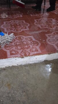 Sweeping Water Off Concrete Floor with Broom