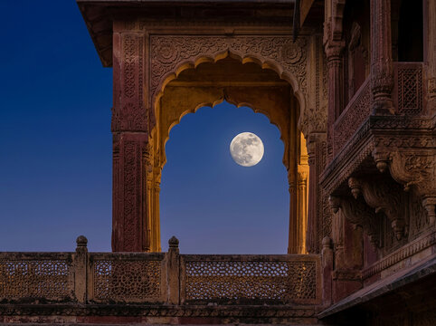 Full Moon Framed by a Scalloped Sandstone Arch and Ornate Heritage Balcony