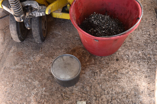 Industrial scrap metal in red bucket on workshop floor