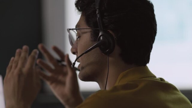 IT Support Specialist speaks through headset beside monitor, delivering clear technical guidance from office service workspace, bringing office service understanding into office practice.